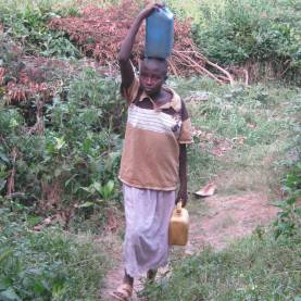 A girl child returns from collecting water in a shallow well in western Uganda.